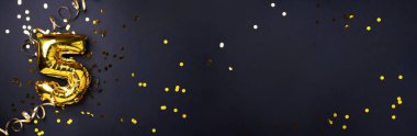 Altın folyo balon numarası ve rakam 5-5. Doğum günü tebrik kartı. Yıldönümü kutlaması. Pankart. Uzayı kopyala Şık altın rakamlı, açık renkli, parlak, siyah arkaplan. Sayısal rakam