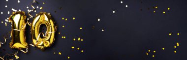 Altın folyo balon numarası, on numara. Doğum günü tebrik kartında 10 yazılıydı. Yıldönümü kutlaması. Pankart. Altın rakamlı, siyah arkaplan. Sayısal rakam, ışık bokeh, parıltı.