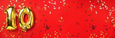 Altın folyo balon numarası, on numara. Doğum günü tebrik kartında 10 yazılıydı. Yıldönümü kutlaması. Pankart. Altın rakamlı, kırmızı arkaplan. Sayısal rakam, ışık bokeh, parıltı.