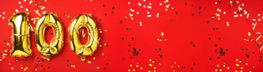 Altın folyo balon numarası, 100 haneli rakam. Doğum günü tebrik kartında 100 yazılıydı. Yıldönümü kutlaması. Pankart. Altın rakamlı, kırmızı arkaplan. Sayısal rakam, ışık bokeh, parıltı.