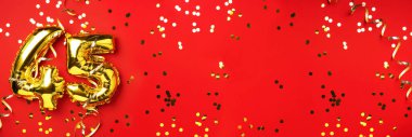 Altın folyo balon numarası, 45 haneli rakam. 45 yazılı doğum günü tebrik kartı var. Yıldönümü kutlaması. Pankart. Altın rakamlı, kırmızı arkaplan. Sayısal rakam, ışık bokeh, parıltı.