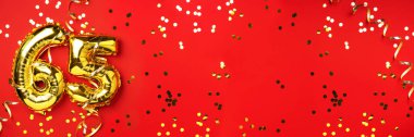 Altın folyo balon numarası, altmış beş. Altmış beş yazılı doğum günü tebrik kartı. Yıldönümü kutlaması. Pankart. Altın rakamlı, kırmızı arkaplan. Sayısal rakam, ışık bokeh, parıltı.
