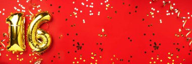 Altın folyo balon numarası, sayı 16. Doğum günü tebrik kartı, 16. yazı. Yıldönümü kutlaması. Pankart. Şık altın rakamlı, parlak, kırmızı arkaplan. Sayısal rakam.