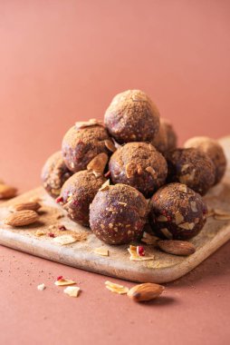 Kurutulmuş meyve ve fındıklı ev yapımı vejetaryen çikolatalı trüf mantarları ahşap arka planda karıştırılır. Sağlıklı tatlılar. Enerji vejetaryen topları, hurma, kakao ve badem gevrekleri..