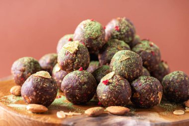 Kurutulmuş meyve ve fındıklı ev yapımı vejetaryen çikolatalı trüf mantarları ahşap arka planda karıştırılır. Sağlıklı tatlılar. Enerji vejetaryen topları, hurma, kakao ve badem gevrekleri..