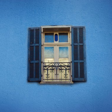 Beton duvardaki eski mavi boyalı pencereler. Fotokopi alanı olan pankart. Pop sanat konsepti, Yunan tarzı pencere. Kare mahsul