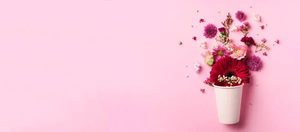 Creatieve lay-out gemaakt van wit papieren bekertje met roze bloemen. Vlakke lay, bovenaanzicht. Banner met kopieerruimte. Valentijnsdag, vrouwendag concept. Lente of zomer banner met kopieerruimte — Stockfoto