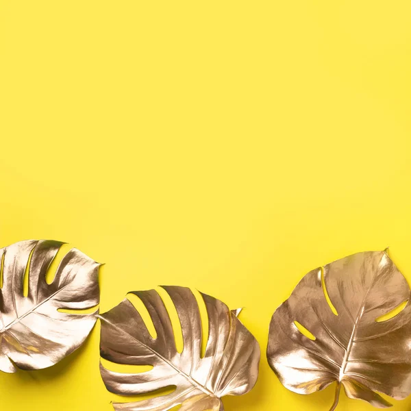 Floral minimale stijl concept. Exotische zomertrend. Gouden tropische palm monstera blad op gele kleur achtergrond. Glanzend en sprankelend design, modeconcept. — Stockfoto