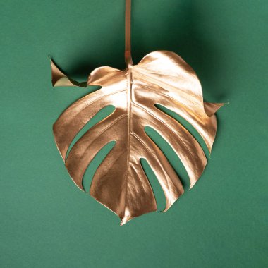 Çiçek biçimi konsepti. Egzotik yaz trendi. Yeşil arka planda altın tropikal palmiye yaprağı. Parlak ve ışıltılı tasarım, moda konsepti.