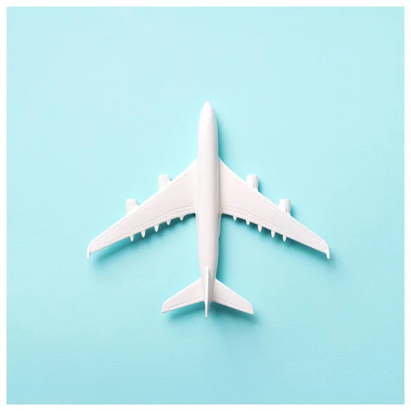 Viagens, conceito de férias. Avião modelo branco em fundo de cor azul pastel com espaço de cópia. Vista superior. Deitado. Design de estilo mínimo. Culturas quadradas — Fotografia de Stock