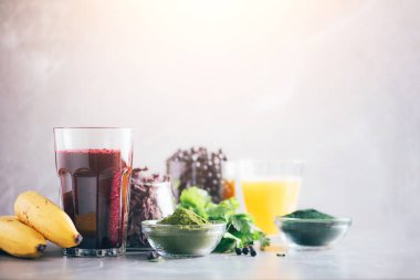 Taze yaban mersini, yabanmersini, arpa otu suyu, spirulina, portakal suyu, mermer arka planda dulse ve kişniş. Ağır metaller detoks smoothie. Sağlıklı beslenme, alkali beslenme, vegan konsepti.