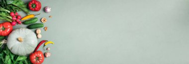 Vegan ve vejetaryen diyeti, hasat konsepti. Yeşil arka planda sonbahar sebzeleri. Üst Manzara. Pişirmek için gerekli malzemeler - kabak, domates, salatalık, biber, pancar, kereviz, sarımsak, turp