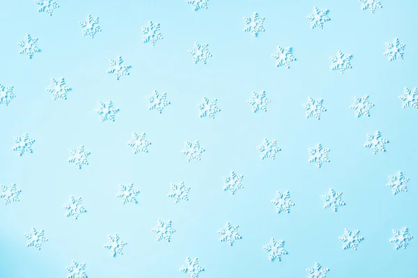 Patrón de invierno hecho de copos de nieve blancos sobre fondo azul. Vista superior. Acostado. Composición de invierno. Navidad, concepto de año nuevo. — Foto de Stock