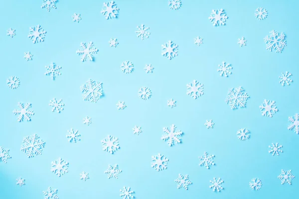 Patrón de invierno hecho de copos de nieve blancos sobre fondo azul. Vista superior. Acostado. Composición de invierno. Navidad, concepto de año nuevo. — Foto de Stock
