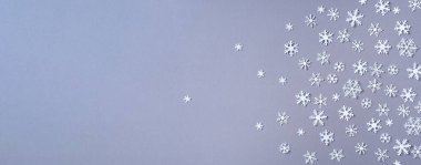 Gri zemin üzerinde beyaz kar tanelerinden oluşan kış deseni. Üst Manzara. Düz yatıyordu. Kış kompozisyonu. Noel, yeni yıl konsepti.