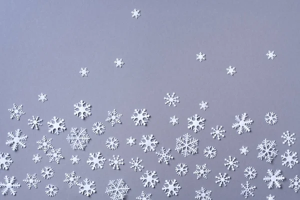 冬の構図。クリスマス、新年のコンセプト。最上階だ。平置きだ。灰色の背景に白い雪片で作られた冬のパターン. — ストック写真