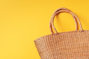 Moda sarı arka planda el yapımı yaz çantası. Üst Manzara. Modaya uygun bir aksesuar. Doğal, organik, çevre dostu, sıfır atık, plastiksiz konsept.