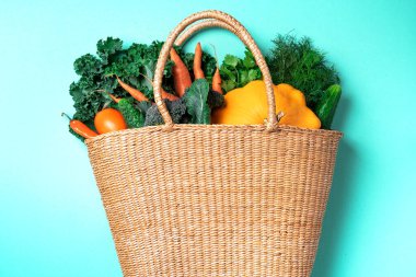 Sonbahar hasadı. Sıfır atık, plastiksiz konsept. Sürdürülebilir yaşam tarzı. Şükran Günü. Yeşil arka planda sağlıklı organik sebzelerle dolu saman sepeti, boşluğu kopyala.