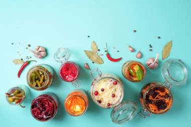 Mavi arka planda çeşitli mayalanmış ve marine edilmiş yiyecekler, kopyalama alanı. Üst Manzara. Pankart. Mayalanmış sebze, lahana turşusu, biber, sarımsak, pancar, Kore havucu, salatalık turşusu.