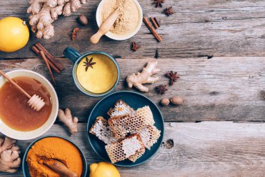 Sıcak, sağlıklı bir içecek. Zerdeçal latte, zerdeçal köklü altın süt, zencefil tozu, ahşap arka planda kara biber. Uzayı kopyala Ayurvedik tedavi için baharatlar. Alternatif tıp konsepti.