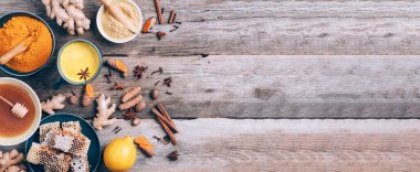 Sıcak, sağlıklı bir içecek. Zerdeçal latte, zerdeçal köklü altın süt, zencefil tozu, ahşap arka planda kara biber. Uzayı kopyala Ayurvedik tedavi için baharatlar. Alternatif tıp konsepti.