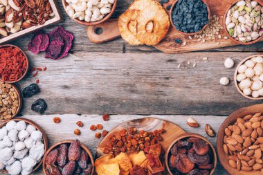 Fındık ve kurutulmuş meyve çeşitleri - Brezilya cevizi, kaju, ceviz, badem, macadamia, çam fıstığı, fındık, ananas, kuru kayısı, goji, papaya, incir, ahşap zemin üzerinde dut