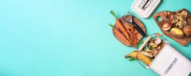 Mavi arka planda beyaz gübre kutusunda soyulmuş sebzeler. Mutfaktan arta kalan gübrelerle birlikte mavi arka planda çöp tenekesi. Üst Manzara. Çorba geri dönüşümü konsepti. Sürdürülebilir ve sıfır atık