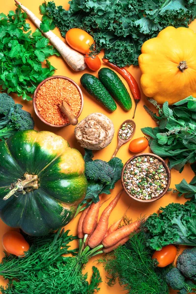 Веганская и вегетарианская диета, концепция урожая. Осенние овощи, чечевица, бобы, сырые ингредиенты для приготовления пищи на модном желтом фоне. Здоровое, чистое питание. Принято. Вид сверху. — стоковое фото