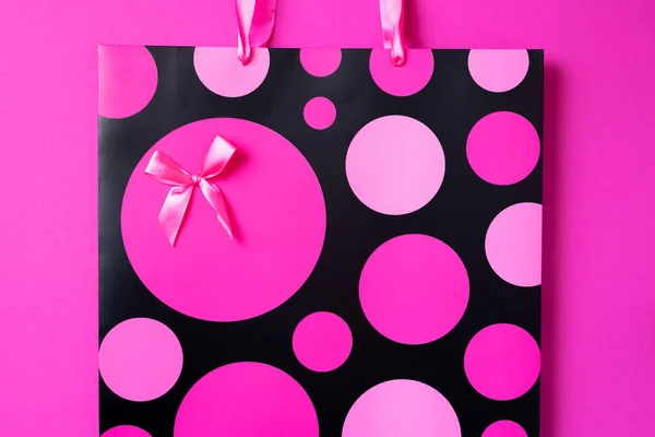 Concept de vente Black Friday. Vue du dessus du sac à provisions en papier rose sur fond lumineux tendance. Espace de copie. Journée des femmes. Saint Valentin. Prêt pour la fête d'anniversaire. — Photo