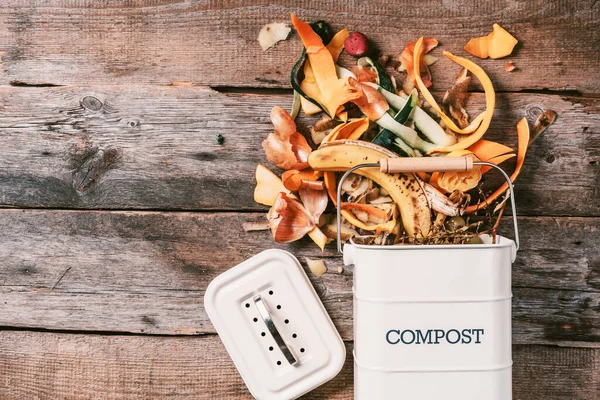 Garbage sorting. Organic food waste from vegetable ready for recycling in compost bin on wooden backgrond. Top view. Sustainable and zero waste living. Environmentally responsible behavior, ecology — Stock Photo, Image