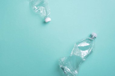Mavi arka planda plastik şişeler. Üst Manzara. Plastik geri dönüşümü, atık kirliliği konsepti. Üst görünüm, boşluğu kopyala. Çevre koruma kavramı. Çöpü tekrar kullan, plastiksiz. Dünya, dünya su günü