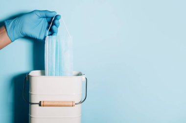 Tıbbi eldivenleri teslim et, tıbbi maskeyi mavi arka plandaki çöp kutusuna at. Karantina sona erdi. Covid 19. Coronavirus sonu kavramı. Fotokopi alanı olan pankart. Kendine dikkat et. Sağlık koruma ekipmanları