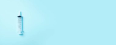 Mavi arka planda şırınga ve iğne. Enjeksiyon ve aşı konsepti. Karantina Coronavirus salgını sırasında sağlık ekipmanları