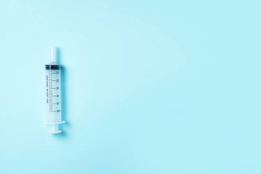 Mavi arka planda şırınga ve iğne. Enjeksiyon ve aşı konsepti. Karantina Coronavirus salgını sırasında sağlık ekipmanları