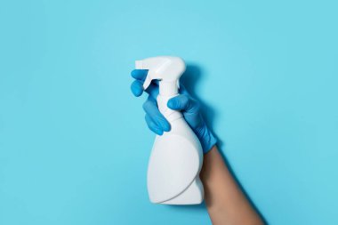 Eldivende beyaz plastik temizlik ürünü şişesi ve ev yapımı kimyasallar var. Uzayı kopyala Temizlik hizmeti konsepti. Kimyasal temizlik ürünleri, fırçalar ve malzemeler. Deterjan şişesi.