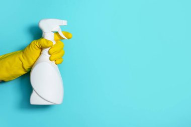 Eldivende beyaz plastik temizlik ürünü şişesi ve ev yapımı kimyasallar var. Uzayı kopyala Temizlik hizmeti konsepti. Kimyasal temizlik ürünleri, fırçalar ve malzemeler. Deterjan şişesi.