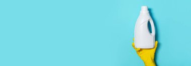 Eldivende beyaz plastik temizlik ürünü şişesi ve ev yapımı kimyasallar var. Uzayı kopyala Temizlik hizmeti konsepti. Kimyasal temizlik ürünleri, fırçalar ve malzemeler. Deterjan şişesi.