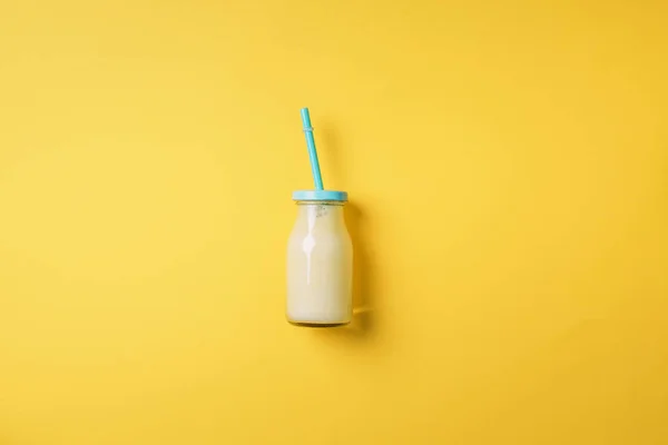 Flessen van oranje, witte, roze smoothie met rietjes op gele achtergrond. Bovenaanzicht. Plat gelegd. Begrepen, ruimte. Detox zomerdrankje. Gezonde verse sapfles. Veganistisch en vegetarisch concept. — Stockfoto