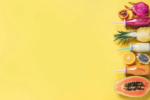 디톡스 여름 음료. 채식, 채식, 프루프턴 틴 다이어트. 신선 한 스무디 와 즙 이 많은 과일들 - 파파야 , 오렌지 , 파인애플 , 용과 , 피파하야 , 타 마릴로 열매들 - 이 노란색 배경 위에 있다. 맨 위 뷰, 평평 한 면 — 스톡 사진