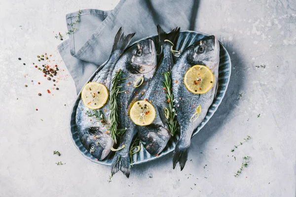 Dorado não cozido ou peixe dourado com limão, ervas, óleo, legumes e especiarias em fundo de concreto. Vista superior. Conceito de alimentação saudável. Espaço para cópia. Padrão alimentar — Fotografia de Stock