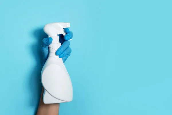Рука в рукавичці тримає білу пластикову пляшку для очищення продукту, побутові хімічні речовини. Копіювати простір. Концепція прибирання. Побутові хімічні засоби для чищення, щітки та приладдя. Пляшка для миючих засобів — стокове фото