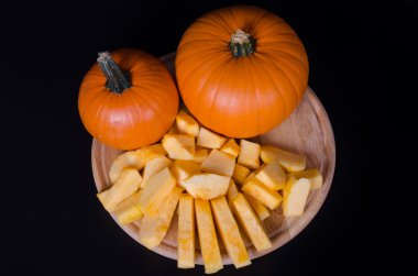 İki Balkabağı ve siyah bir backgroung ahşap tahta dilimleri