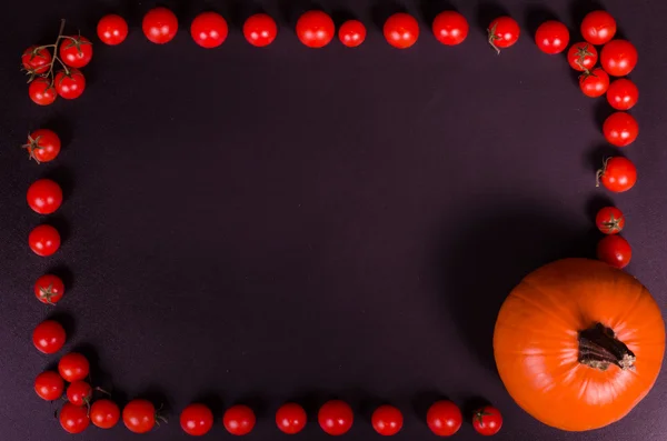 Legumes frescos em uma mesa preta. Fundo de outono. Quadro alimentar saudável. Abóbora, cereja de tomates — Fotografia de Stock