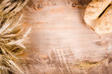 Taze ekmeği ve ahşap arka plan buğday kulaklara. Çerçeve