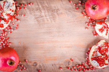 Olgun nar meyve ve tohumlar ahşap arka plan üzerinde. Çerçeve yeme. Metin için boş alan