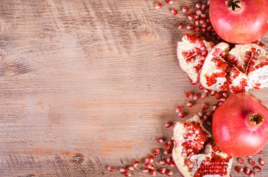 Olgun nar meyve ve tohumlar ahşap arka plan üzerinde. Çerçeve yeme. Metin için boş alan