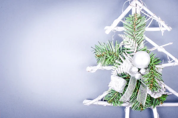 Árbol nevado de Navidad con bolas de plata y regalo sobre fondo azul. Decoración de Año Nuevo de madera. Espacio libre para texto — Foto de Stock