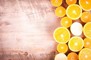 Dilimlenmiş portakal ve limon yığını bir closeup ahşap arka plan üzerine dilimlenmiş. Çerçeve yeme. Metin için boş alan