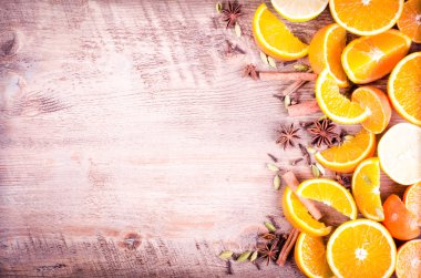 Ahşap arka plan üzerinde baharatlar ile dilimlenmiş portakal ve limon yığını bir closeup dilimlenmiş. Çerçeve yeme. Metin için özgür yer. Noel