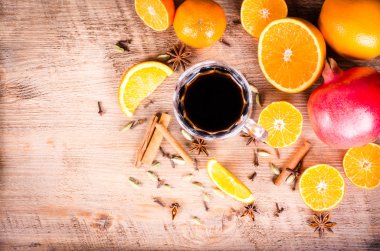 Baharatlar ve suyu, ahşap arka plan üzerinde şarap ile dilimlenmiş portakal, limon, nar yığını bir closeup dilimlenmiş. Çerçeve yeme. Metin için özgür yer. Noel